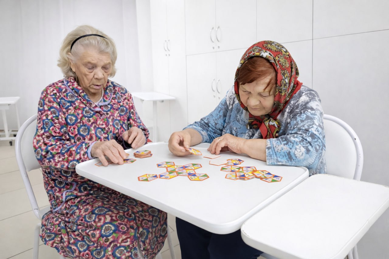 Пожилые женщины играют в настольную игру в пансионате Новая медицина