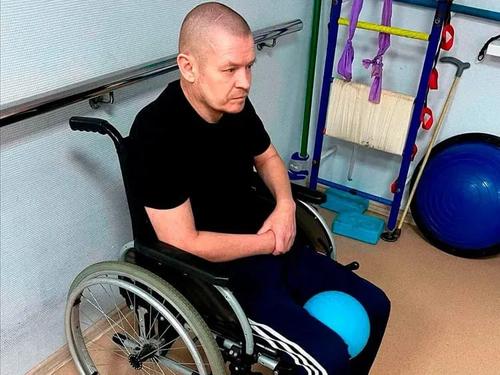 Пожилой мужчина в кресле-коляске в зале для занятий